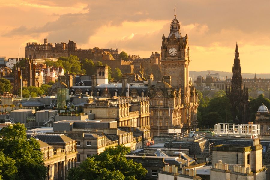 A photo of Edinburgh taken at dusk. The castle is in the background on the left of the image.