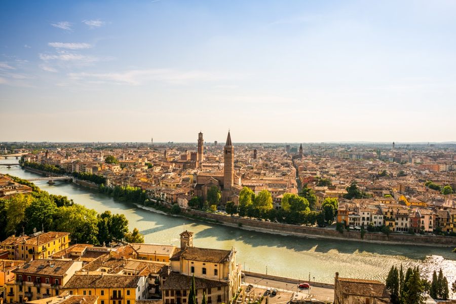 A photo of Verona’s rooftops and the river running through the city, taken on a bright and sunny day.