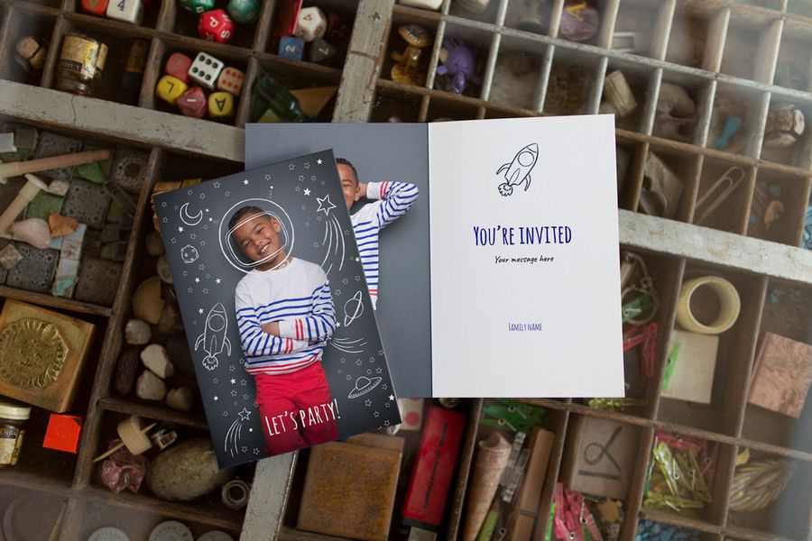 Two customised birthday photo cards, one with a photo of a boy on the front with astronaut and spaced-themed illustrations around him, the other is the same card design but open